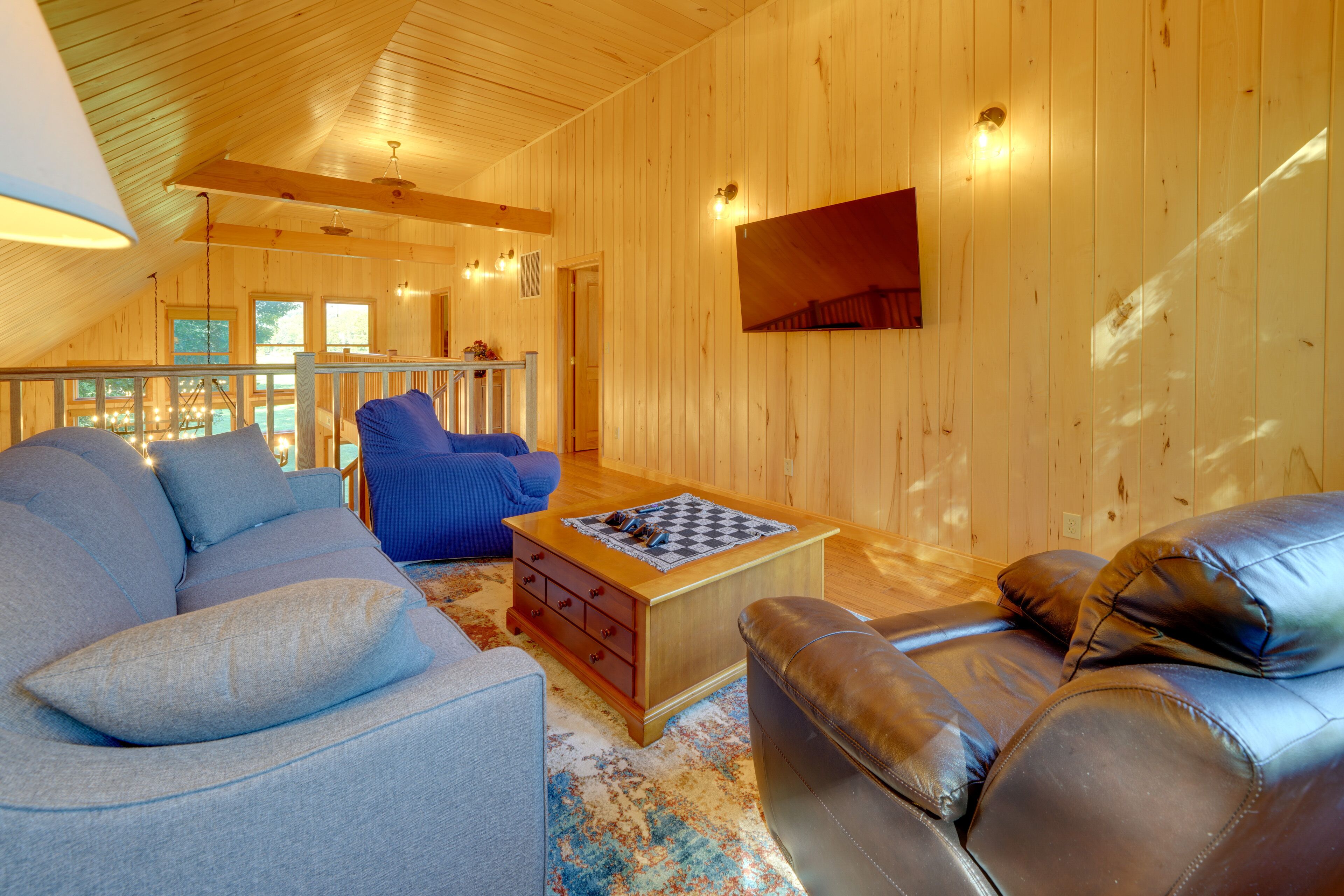 Un intérieur chaleureux, avec des boiseries, un canapé, un fauteuil en cuir et une table basse.