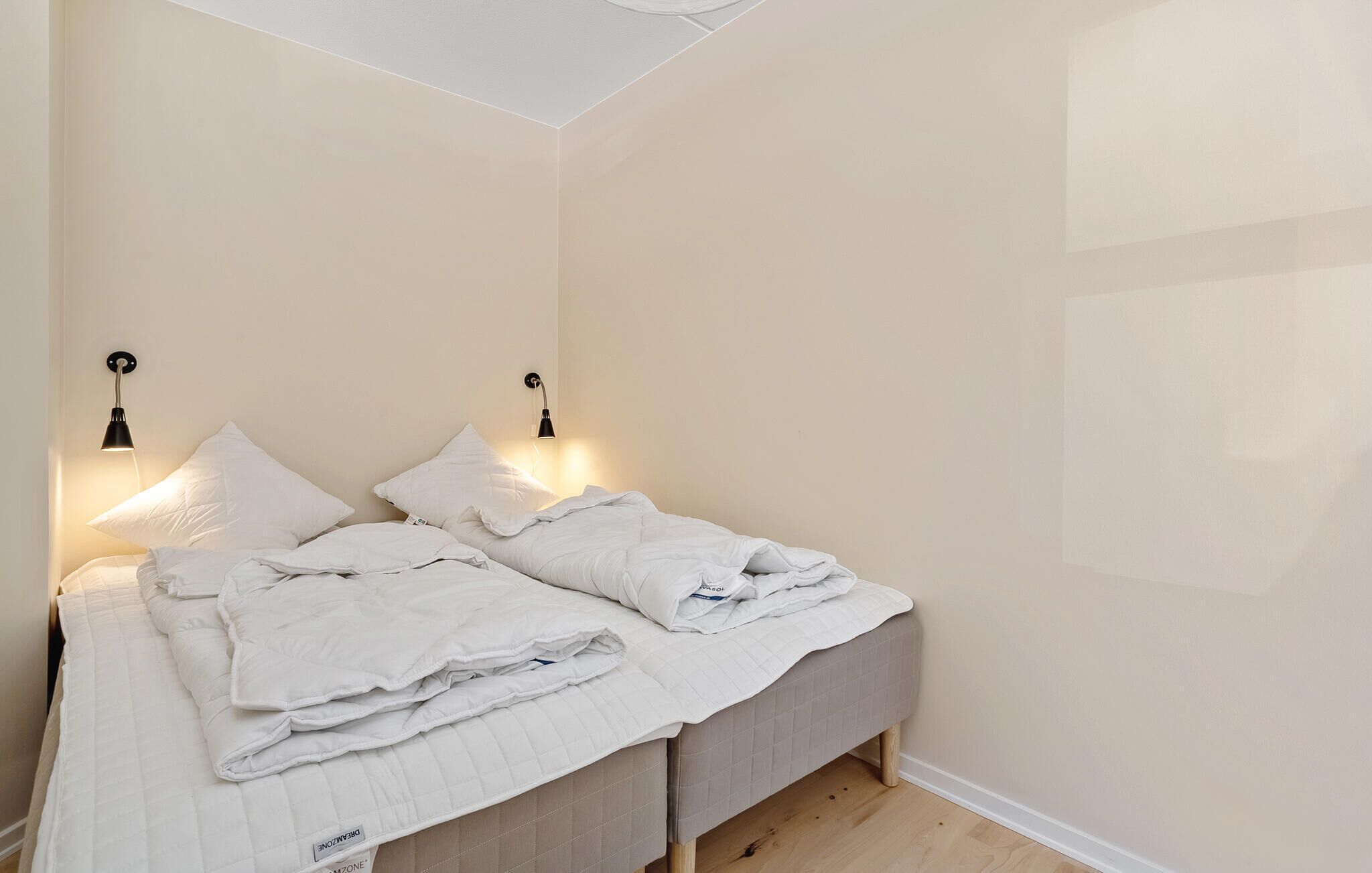 Ein Schlafzimmer mit einem Bett, zwei Nachttischlampen und einem Deckenventilator.