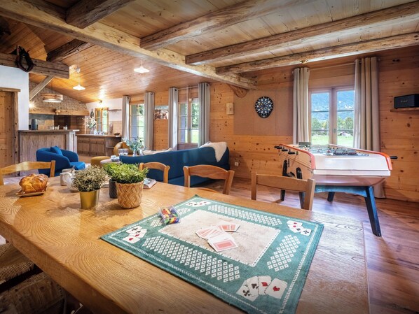 Ein gemütliches Holzhaus-Interieur mit Essbereich, Kicker und Dartscheibe.