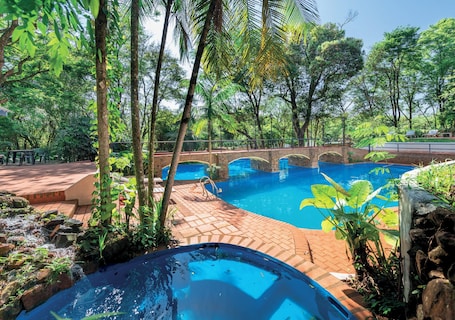 Una piscina al aire libre, sillones reclinables de piscina