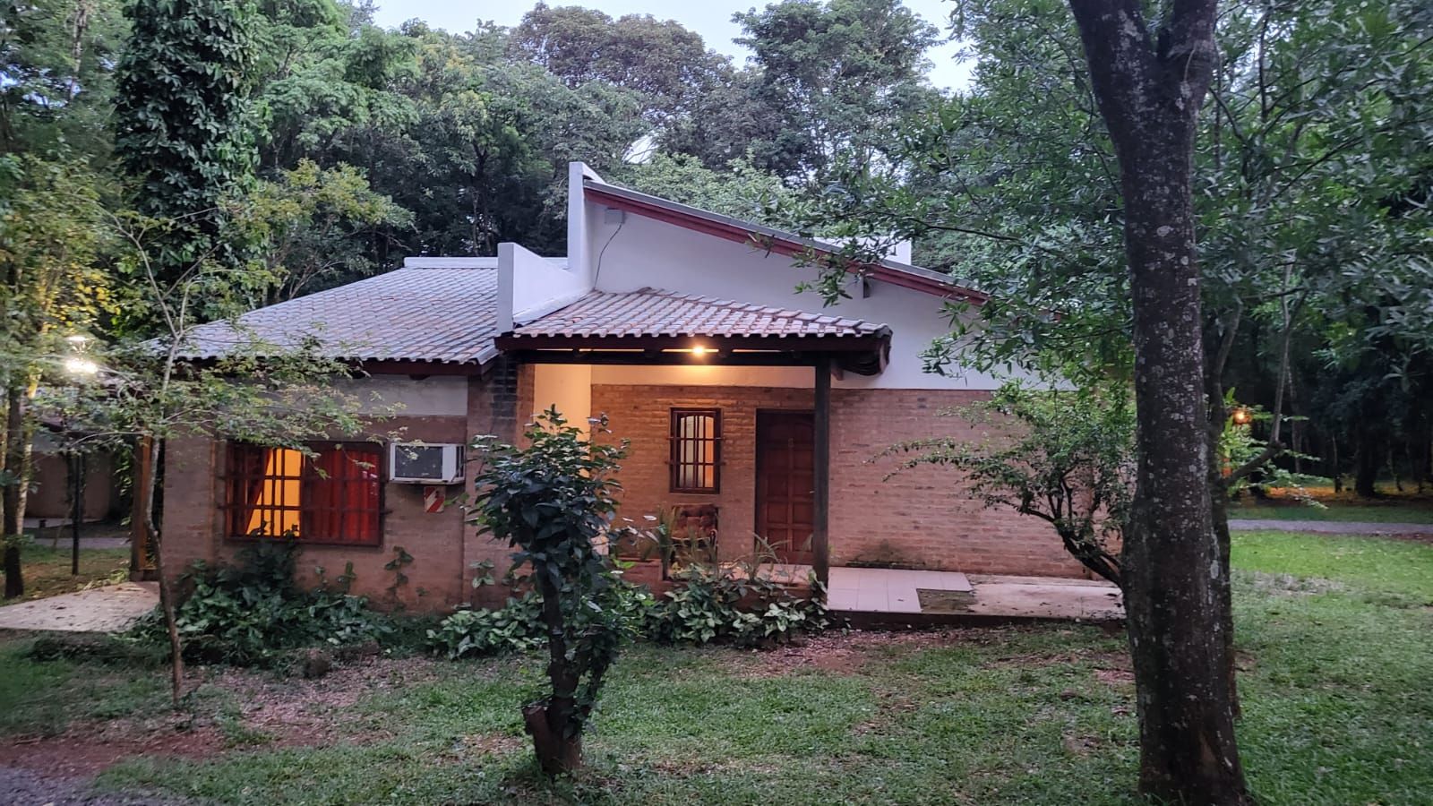 A single-story house with a tiled roof, a brick exterior, and a small front porch.
