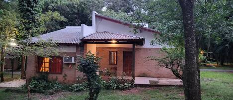 A single-story house with a tiled roof, a brick exterior, and a small front porch.