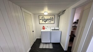 A laundry room with two washing machines, a sign above them, and a black tiled floor. - Heart of Richfield, ATVs & Mountain Biking, Spacious Home, Sporting Events (Richfield)