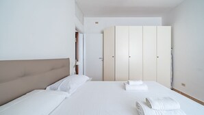 Une chambre d’hôtel avec un lit, une armoire et une table de chevet.