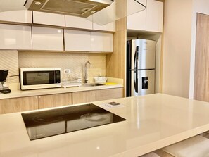 Apartamento superluxo, 2 quartos | Cozinha privada | Geladeira, micro-ondas, cooktop, lava-louças