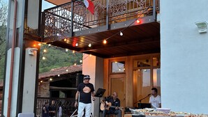 An outdoor patio with a stage, string lights, and a buffet table. - GROUP STAY 39 GUESTS - POOL TENNISCOURT (Liguria)