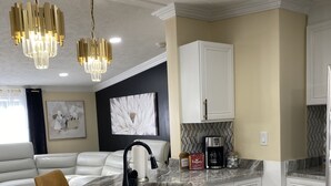 A modern kitchen with marble countertops, white cabinetry, and a built-in island. - Loera’s Inn
Located right off 95 exit Dumfries, 12 minutes from Quantico, VA. (Dumfries)