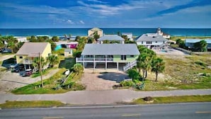 A coastal property with multiple buildings, a paved driveway, and a view of the ocean.