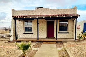 A small, single-story building with a stone facade and a red door. - Casa Monroe Unit 1 (El Paso)