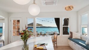 A modern kitchen with a large island, a view of the sea, and a dining area with a view. - Crystal Lake Retreat with hot tub and dock (Beulah)