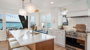A modern kitchen with a large island, stainless steel appliances, and a view of the sea. - Crystal Lake Retreat with hot tub and dock (Beulah)