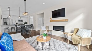 A modern living space with a kitchen, dining area, and seating area. - Modern & Cozy Condo w/Hot Tub! (Sun Peaks)