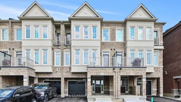 A multi-story residential building with a symmetrical facade, multiple balconies, and a garage. - Your vacation home @Bradford, ON (Bradford West Gwillimbury)