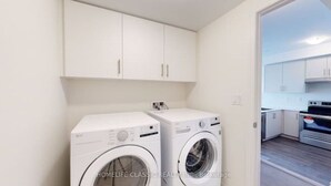 A laundry room with two washing machines and a small countertop. - Your vacation home @Bradford, ON (Bradford West Gwillimbury)