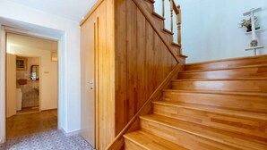 A wooden staircase with a handrail and a landing area.