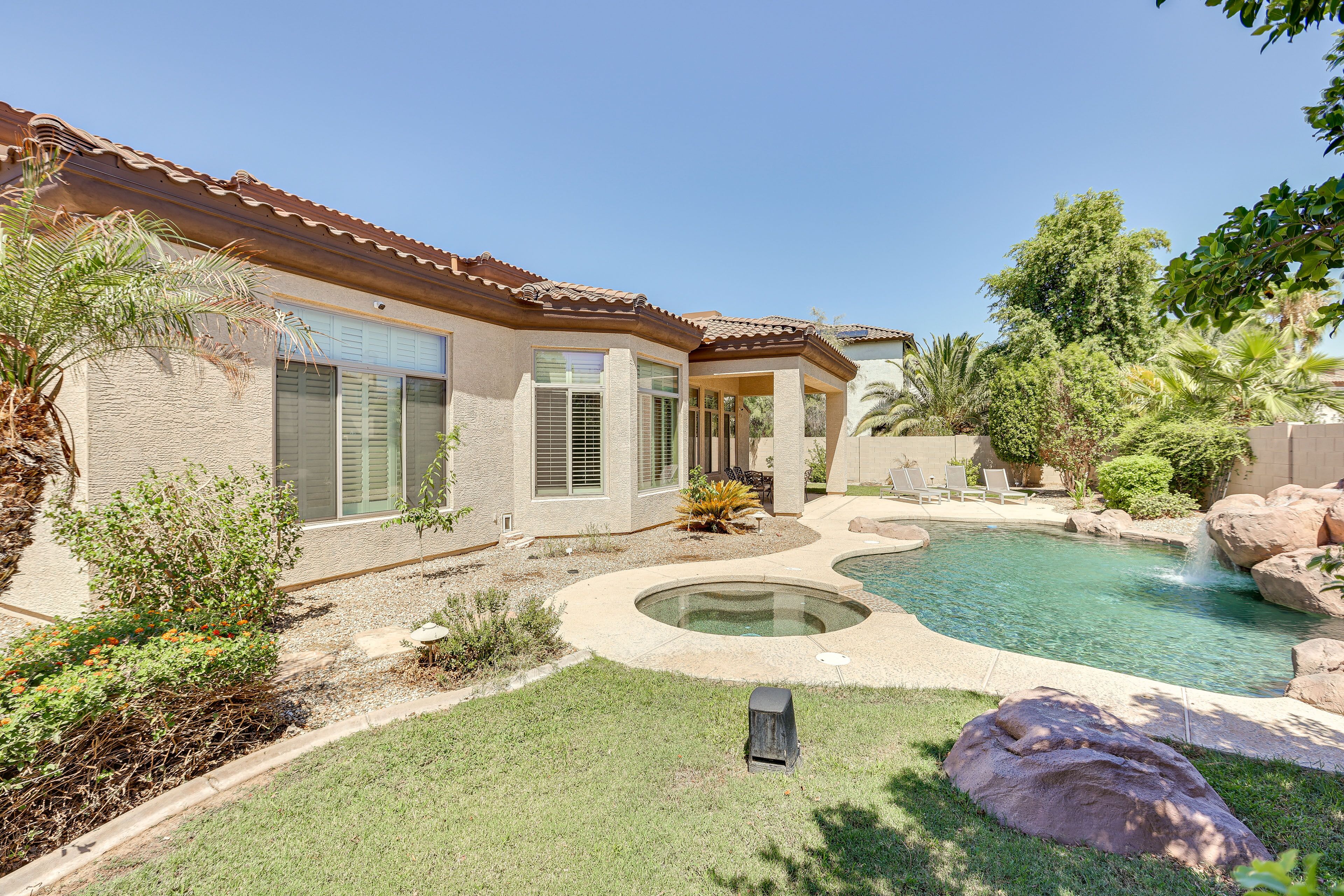 A house with a swimming pool, a patio, and a well-maintained garden.