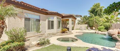 A house with a swimming pool, a patio, and a well-maintained garden.