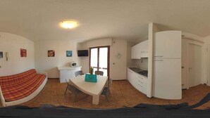Una habitación compacta con cama, un pequeño kitchenette, un comedor y un baño.