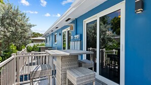A blue building with a balcony, outdoor seating, and a large window. - ~ Prime Location ~ Heated Pool ~ Beach + Nightlife ~ Great Neighborhood! (Pompano Beach)