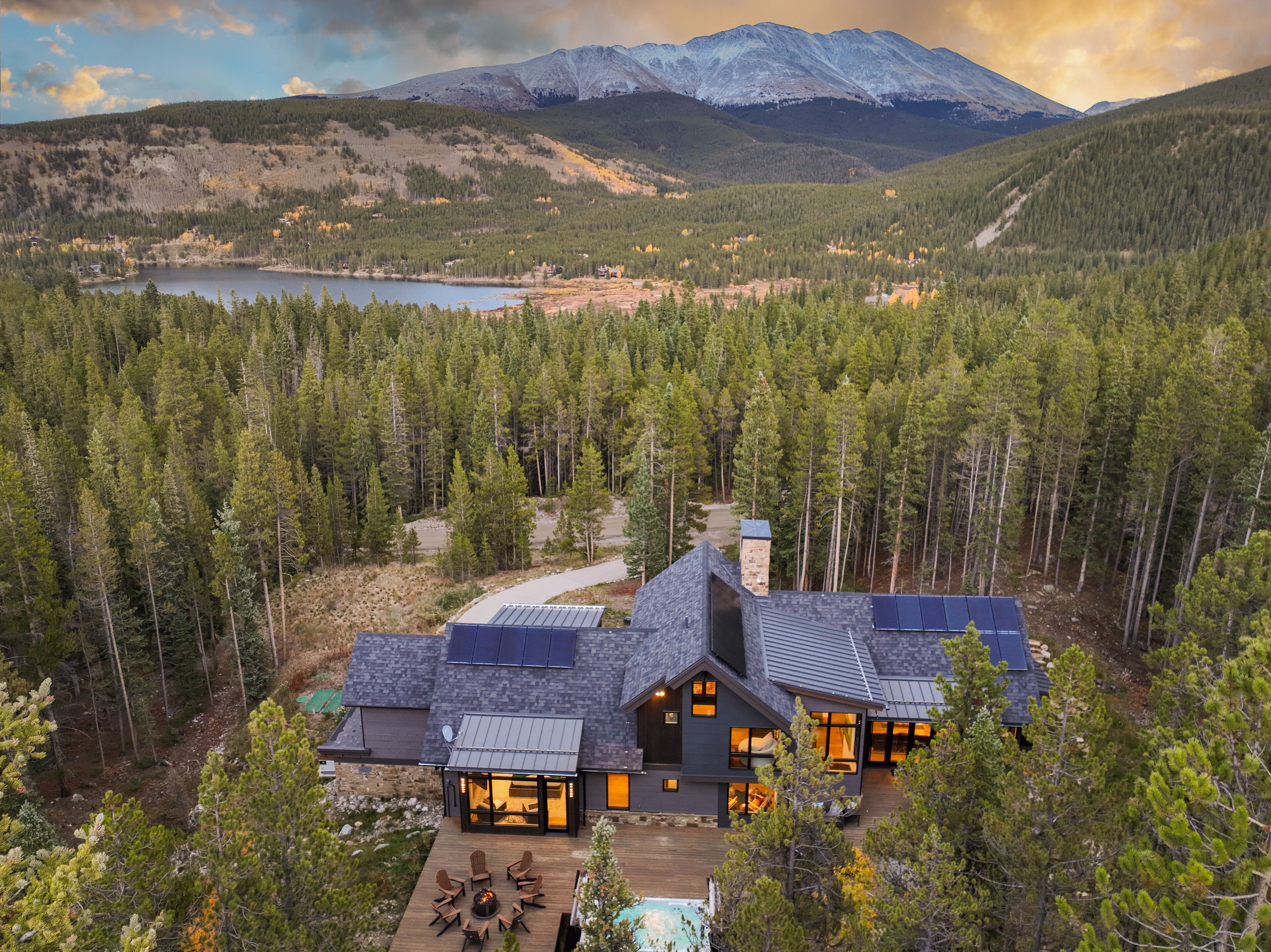 Ein modernes Haus mit Terrasse, Solaranlage und Blick auf See und Berge.