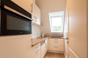 Fridge, stovetop, dishwasher, coffee/tea maker