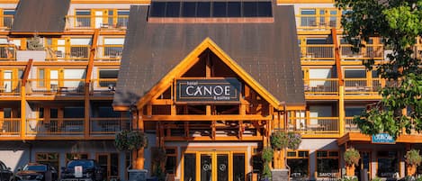 A multi-story hotel with a prominent sign reading 'Canoe & Suites.'