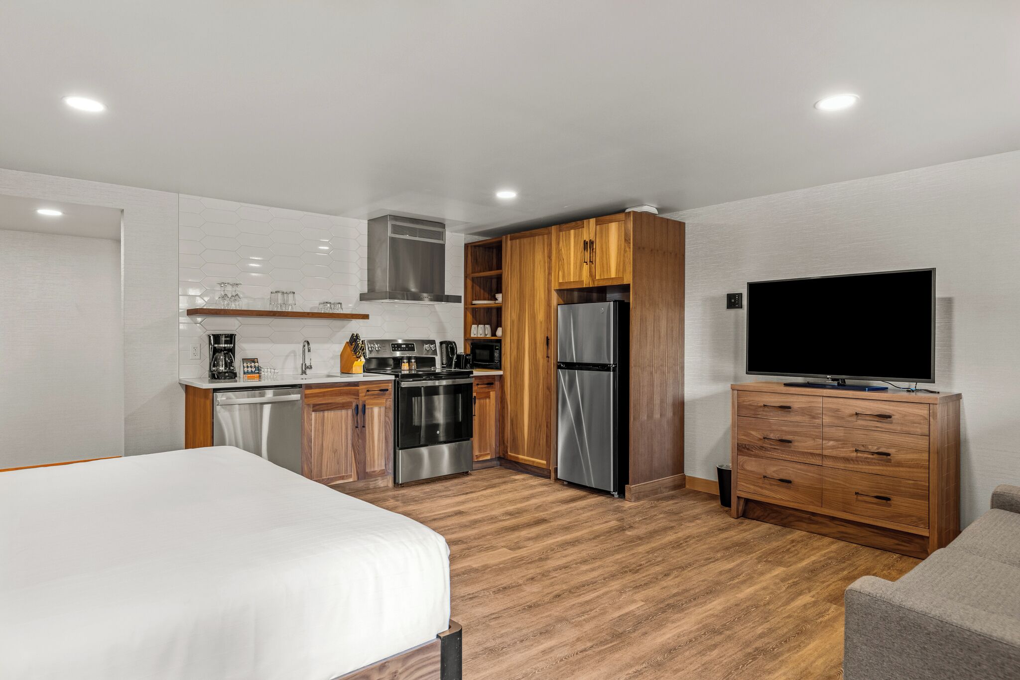 A compact kitchen with wooden cabinets, a refrigerator, and a microwave.