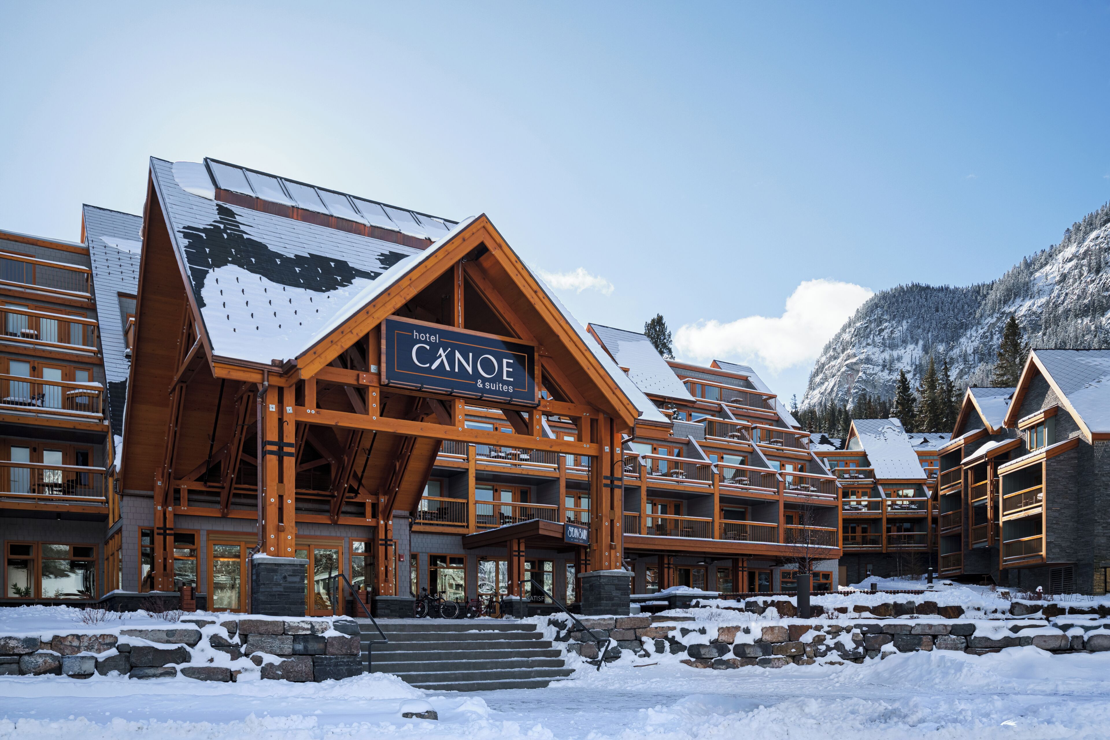 A lodge with a prominent sign reading 'Canoe & Suites' and a stone facade.