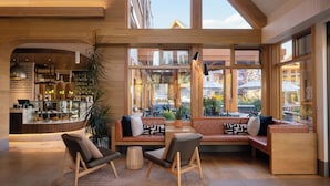 A spacious indoor area with a seating area, a counter with a display of items, and large windows providing views of the outside.