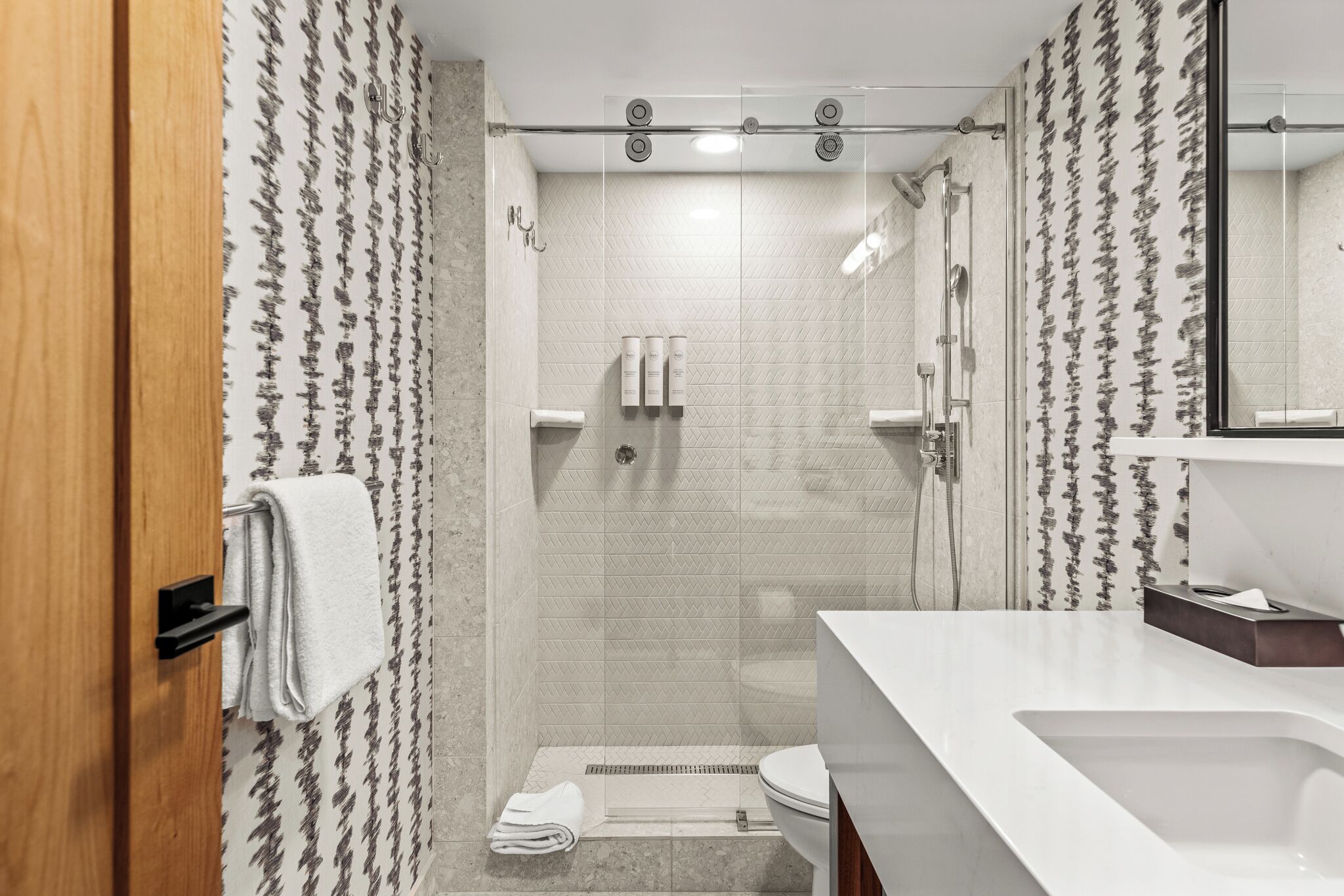 Un bagno moderno con doccia, toilette e lavandino.