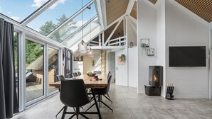Ein moderner Essbereich mit einem großen Tisch, Stühlen und einem Kamin.