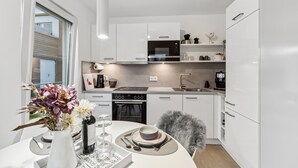 A modern kitchen with white cabinetry, a built-in oven, and a coffee machine. - Gorgeous home in Tossens with sauna (Tossens)