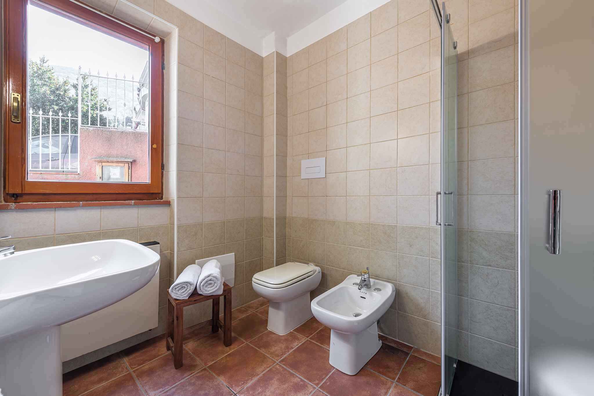 A bathroom with a bathtub, a toilet, a bidet, and a glass shower enclosure.