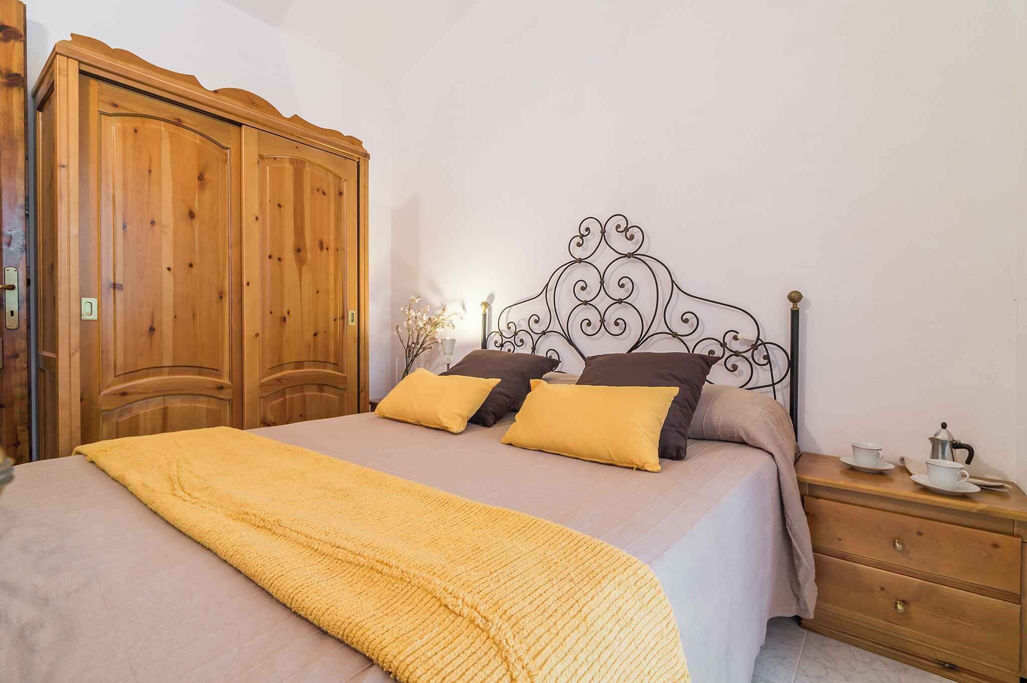 Ein Schlafzimmer mit einem Bett, einem Holzschrank und einem Nachttisch mit Tasse und Untertasse.