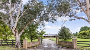 A gravel driveway leading to a gated entrance with a brick wall and a sign that reads "BARRINGTON PARK." - Mountain Culture Farm Stays  (Kanimbla)