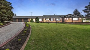 A two-story building with a brick facade, a flat roof, and a well-maintained lawn. - Mountain Culture Farm Stays  (Kanimbla)