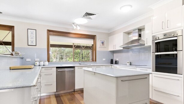A modern kitchen with white cabinetry, stainless steel appliances, and a large window providing natural light. - Mountain Culture Farm Stays  (Kanimbla)