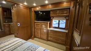 A compact RV kitchen with wooden cabinets, a built-in TV, and a window with a view of the outside. - Enjoy your stay in luxury at Grange for PSU Tailgate, or our Private Lot w/Pool (Bellefonte)