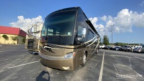 A large RV parked in a parking lot with a building in the background. - Enjoy your stay in luxury at Grange for PSU Tailgate, or our Private Lot w/Pool (Bellefonte)