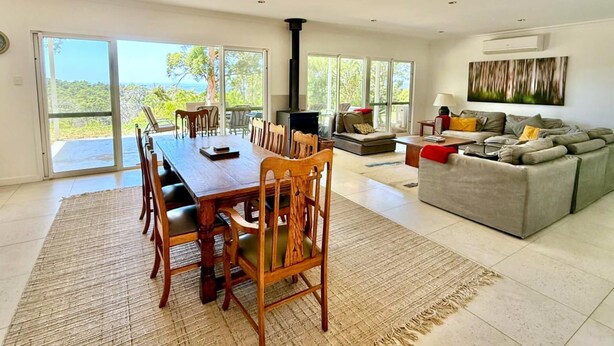A spacious living area with a large dining table, a sofa, and a fireplace.