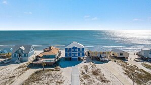 Una propiedad frente al mar con varias casas, una piscina y una playa de arena.