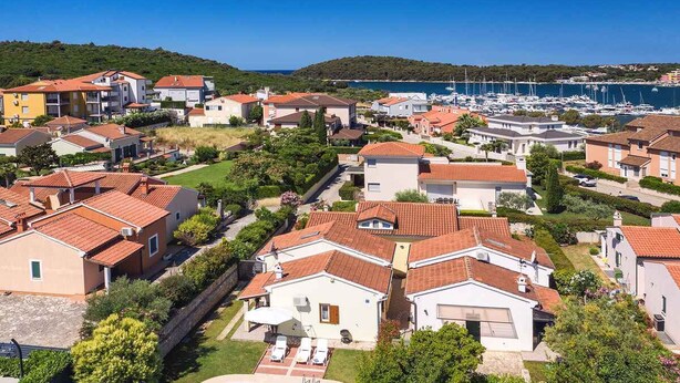 A residential area with houses, a swimming pool, and a marina in the background. - Villa with pool near the beach (Banjole)