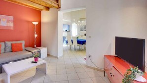 A modern living room with a sofa, a coffee table, a TV, and a dining area in the background. - Villa with pool near the beach (Banjole)