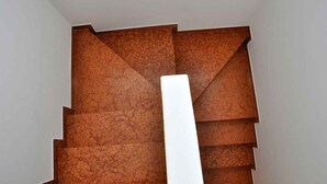 Eine Treppe mit einem einzigartigen geometrischen Design und einer weißen Säule in der Mitte.