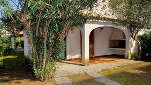 Ein überdachter Außenbereich mit einem Steinweg, der zu einem Rundbogenportal führt.