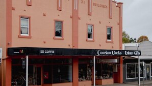 Ein Gebäude mit der Aufschrift "HOLSTON BUILDINGS" und Schaufenstern, darunter "COOKOO CLOCKS" und "Unique Gifts".