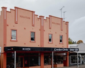 Un edificio con el letrero "HOLSTON BUILDINGS" y escaparates que incluyen "COOKOO CLOCKS" y "Unique Gifts".