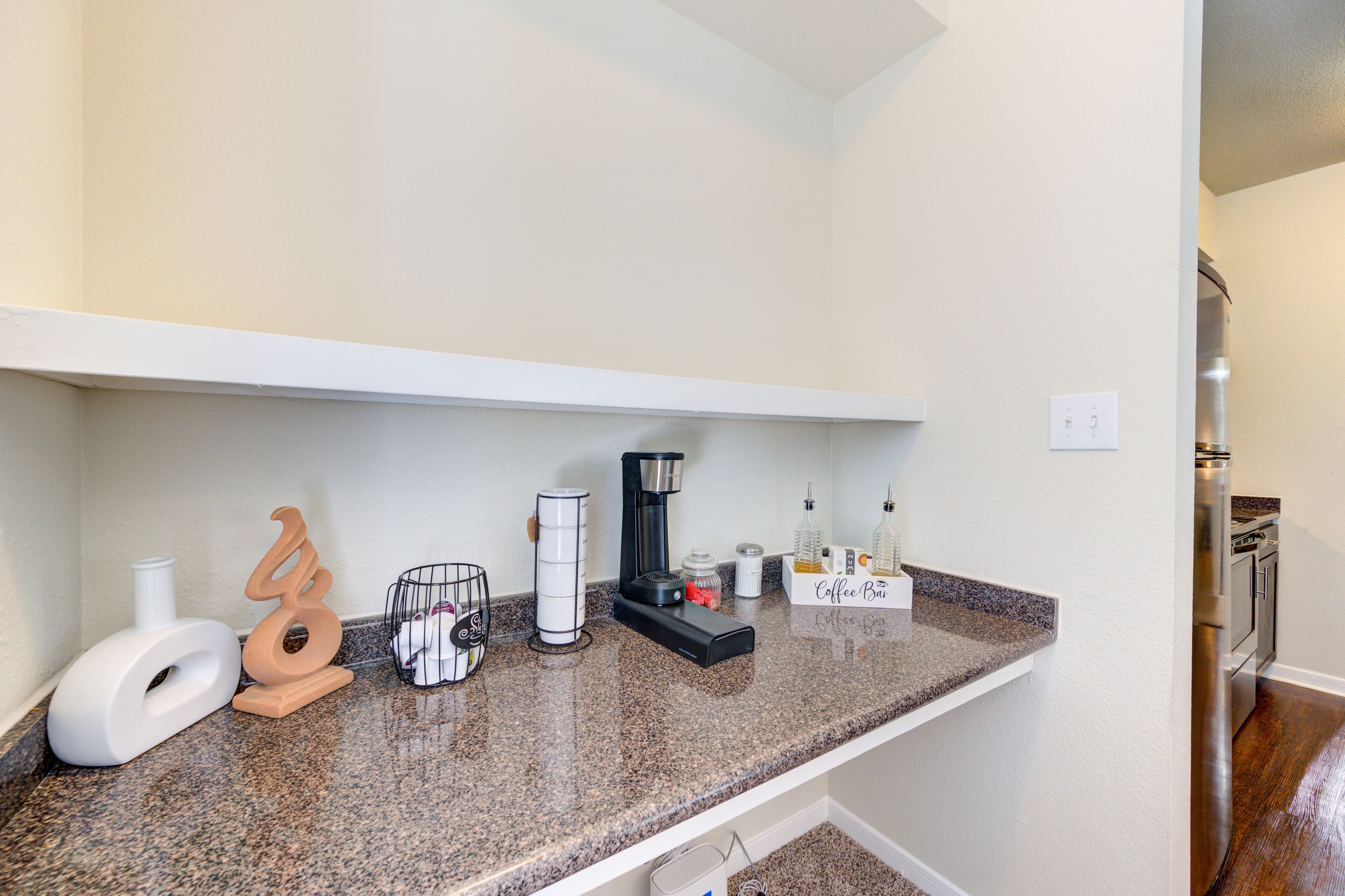 A kitchen counter with a coffee maker, a toaster, and a coffee machine.