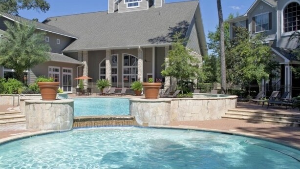 A swimming pool with a stone border, lounge chairs, and potted plants. - Serene Escape in the Pines- shopping, dining, entertainment-Iron Man (Spring)