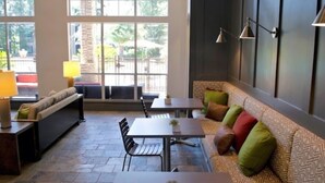 A modern interior with a stone floor, a sofa with colorful cushions, a dining table, and a bench. - Serene Escape in the Pines- shopping, dining, entertainment-Iron Man (Spring)